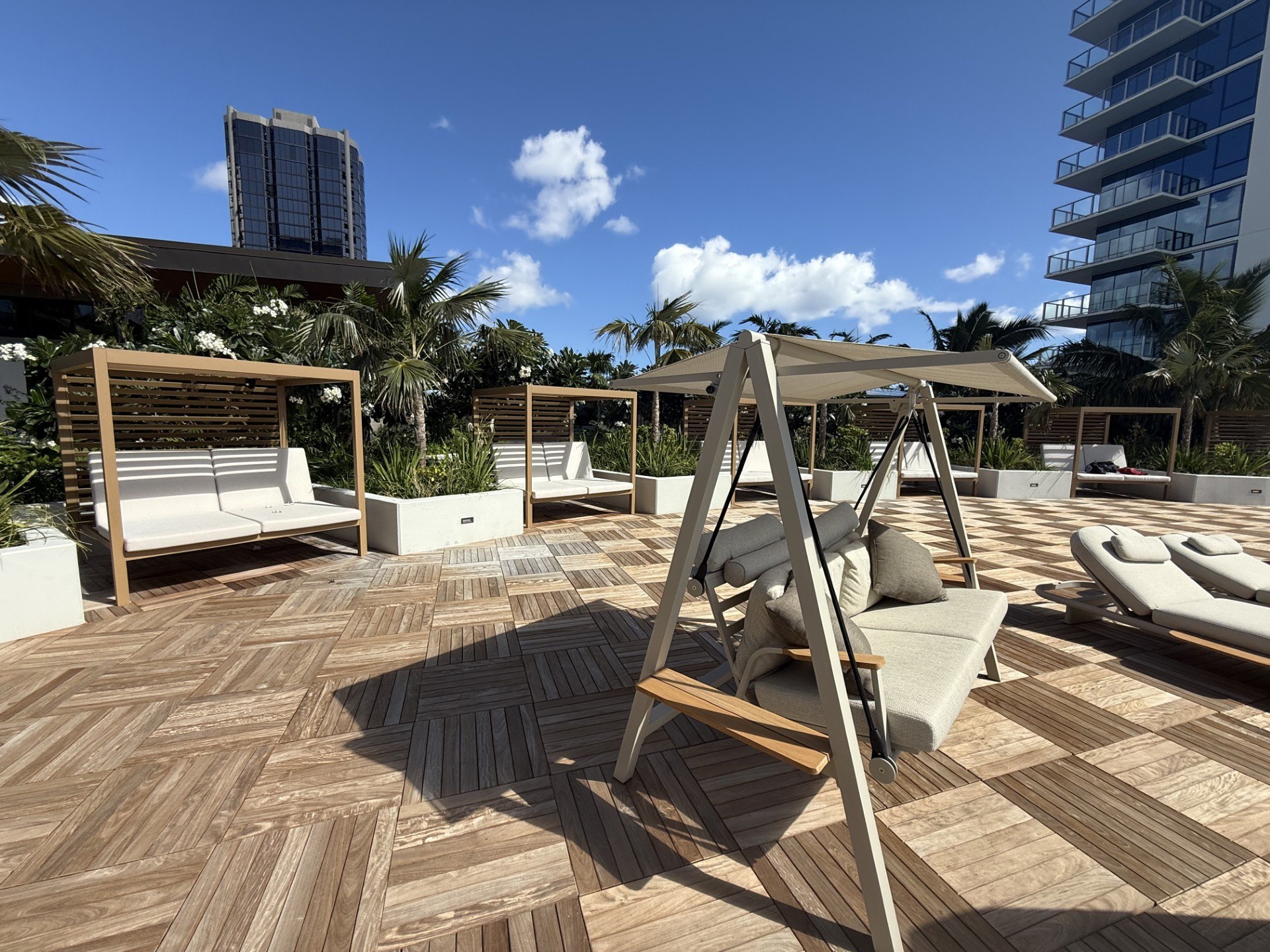 A wooden deck with lounge chairs and a canopy.